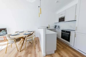 Dining table with chairs and modern kitchen. at Apartment in 12 Rue de l'Arrivée, 75015 Paris, France in Paris Student Accommodation