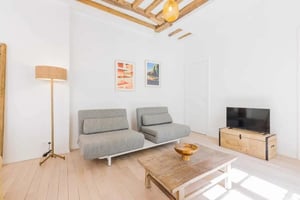 Two gray sofas coffee table and TV living room at Apartment in 48 Rue Chapon, 75003 Paris, France in Paris Student Accommodation