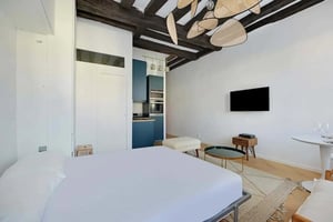 Bed kitchen TV ottoman and coffee table studio apartment at Studio in 22 Rue des Rosiers, 75004 Paris, France in Paris Student Accommodation