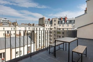Table and benches on balcony overlooking buildings Balcony at Studio in 26 Rue Marcadet, 75018 Paris, France in Paris Student Accommodation