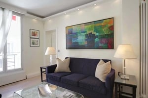 Dark blue couch with beige pillows modern art living room at Apartment in 17 Rue des Acacias, 75017 Paris, France in Paris Student Accommodation