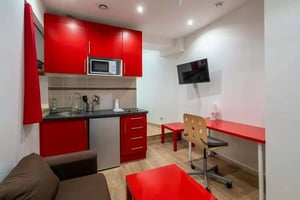 Red cabinets microwave sofa desk and television living room at Studio in Rue de Patay, 75013 Paris, France in Paris Student Accommodation