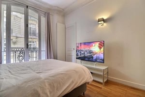 Bed television balcony French windows bedroom at Apartment in Rue Georges ville, 75016 Paris, France in Paris Student Accommodation