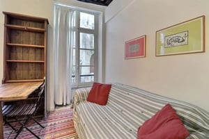 Desk bookshelf striped sofa red cushions bedroom at Studio in Rue du Foin, 75003 Paris, France in Paris Student Accommodation