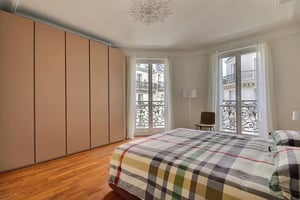 Large wardrobe bed with plaid duvet window bedroom at Apartment in Rue Chevert, 75007 Paris, France in Paris Student Accommodation