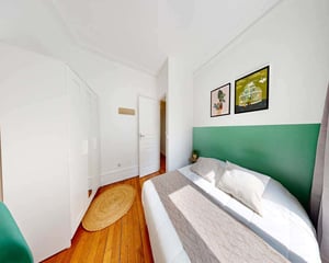 Bed with pillows and a small table bedroom at Chambre dans le rue des Cloys in Paris Student Accommodation