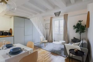 Dining table with grey plates and sofa living room at Apartment in 13 Rue Vieille du Temple, 75004 Paris, France in Paris Student Accommodation