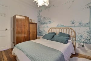 Wooden wardrobes rattan bed mural wallpaper bedroom at Apartment in Rue Salneuve, 75017 Paris, France in Paris Student Accommodation