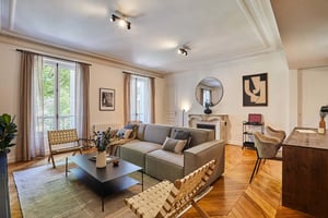 Sofa chairs coffee table fireplace round mirror living room at Apartment in 47 Rue des Mathurins, 75008 Paris, France in Paris Student Accommodation