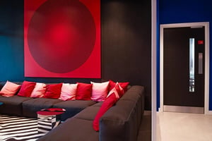Sofa pillows red art and striped rug living room at Vita Student Copper Towers in Coventry Student Accommodation