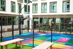 Basketball court with colorful court and benches playing area at Vita Student Cannon Park Warwick in Coventry Student Accommodation