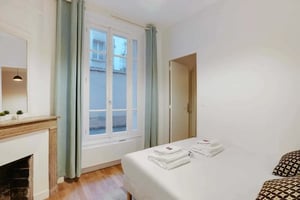 Bed with folded towels fireplace mirror bedroom at Apartment in Docteur Mignot-Guinet, 11 Rue Félix Faure, 75015 Paris, France in Paris Student Accommodation