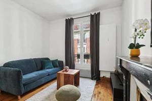 Blue sofa wooden coffee table white rug living room at Apartment in 83 Rue Lamarck, 75018 Paris, France in Paris Student Accommodation