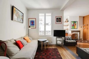 Sofa artwork tables and television living room at Studio in 6 Cr Bérard, 75004 Paris, France in Paris Student Accommodation