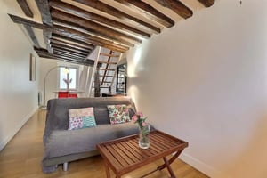 Sofa wooden table staircase exposed beams living room at Apartment in Rue Beauregard, 75002 Paris, France in Paris Student Accommodation