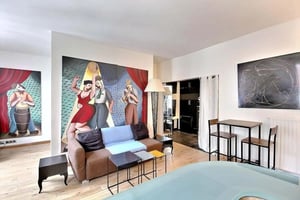 Sofa tables lamp paintings and bar stools living room at Studio in Rue Sainte-Croix de la Bretonnerie, 75004 Paris, France in Paris Student Accommodation