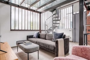 Gray sofa with pillows spiral staircase living room at Apartment in 72 Rue du Commerce, 75015 Paris, France in Paris Student Accommodation