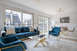 Blue couches coffee table chairs dining table living room at Apartment in 22 Av. Raymond Poincaré, 75116 Paris, France in Paris Student Accommodation