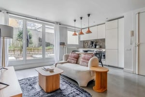 Sofa kitchen area and large windows Living room at Apartment in 57 Rue Dulong, 75017 Paris, France in Paris Student Accommodation