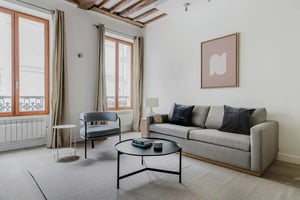 Gray sofa armchair coffee table artwork living room at Apartment in 7 Rue des Canettes, 75006 Paris, France in Paris Student Accommodation