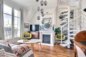 White spiral stairs and yellow chairs living room at Apartment in Rue Régis, 75006 Paris, France in Paris Student Accommodation