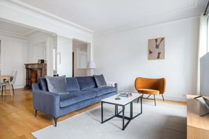 Blue sofa coffee table orange chair living room at Apartment in 186 Bd Haussmann, 75008 Paris, France in Paris Student Accommodation