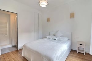 White bed with pillows and bedside table Bedroom at Apartment in Rue Blomet, 75015 Paris, France in Paris Student Accommodation