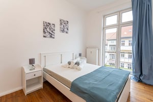 White bed with rolled towels nightstand and artwork Bedroom at Apartment in Boxhagener Str. 49, 10245 Berlin, Germania in Berlin Student Accommodation