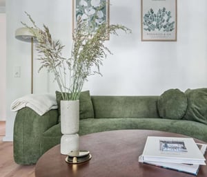 Green sofa framed by artwork and plants living room at Apartment in Finowstraße 21, 10247 Berlin-Bezirk Friedrichshain-Kreuzberg, Deutschland in Berlin Student Accommodation