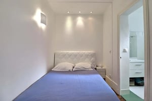 Bed with white headboard purple bedding and nightstand Bedroom at Apartment in Rue Nicolo, 75116 Paris, France in Paris Student Accommodation