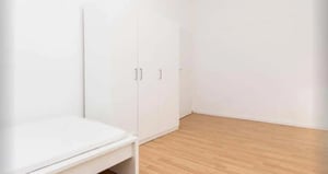 White wardrobe and bed in empty bedroom at Room in Bismarckstraße 72, 10627 Berlin, Germany in Berlin Student Accommodation