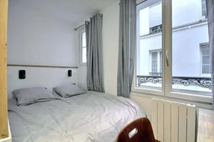 Bed with gray linens and pillows bedroom at Studio in Rue du Square Carpeaux, 75018 Paris, France in Paris Student Accommodation
