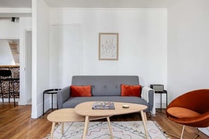 Grey sofa orange pillows art living room at Rue de l'Épée de Bois in Paris Student Accommodation