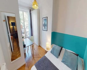 Bed with pillows mirror desk and chair bedroom at Room in 14 Rue de Tilsitt, 75008 Paris, France in Paris Student Accommodation