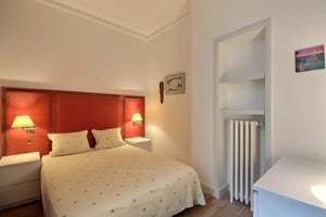 Bed bedside tables lamps red headboard bedroom at Apartment in Rue des Écoles, 75005 Paris, France in Paris Student Accommodation