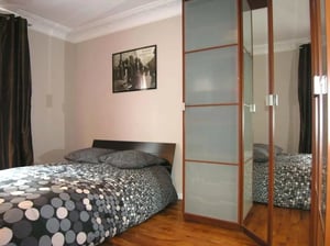 Bed with patterned duvet and mirrored wardrobe bedroom at Apartment 1 bedroom 35m² in Paris Student Accommodation