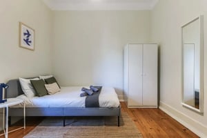 Bed wardrobe mirror and wall art bedroom at Amazing double bedroom in Arroios - Room 1 in Lisbon Student Accommodation