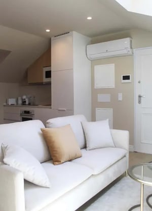White sofa kitchen appliances air conditioner living room at CDOQI - Cozy Studio in Campo de Ourique in Lisbon Student Accommodation