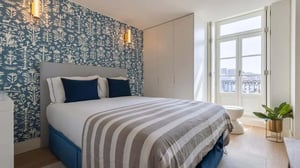 Bed with blue pillows and striped throw bedroom at Ribeira Garden 2BDR Apartment in Lisbon Student Accommodation