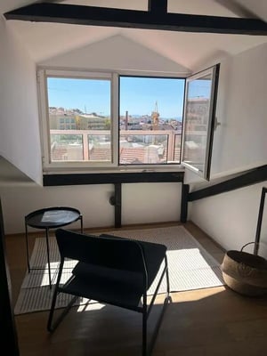 Black chair rug black table city view living room at Apartment in Rua Eduardo Coelho, Lisboa in Lisbon Student Accommodation
