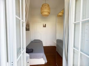 Single bed with grey bedding and towels bedroom at Cosy single room with balcony in a 3-bedroom apartment in Rua Tenente Raul Cascais, Lisbon in Lisbon Student Accommodation