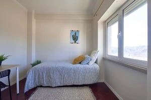 Bed with yellow pillows study desk window bedroom at Bedroom with private bathroom in a 7-bedroom apartment in Lisbon - Room 1 in Lisbon Student Accommodation