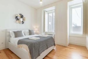 White bed with patterned throw and pillows bedroom at Apartment in Rua de São Julião, Lisboa in Lisbon Student Accommodation