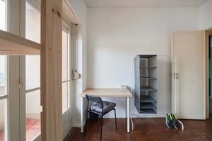 Desk chair shelves and shoes study area at Single bedroom with balcony in a 6-bedroom apartment in Rua Tristão Vaz, Lisbon - Room 1 in Lisbon Student Accommodation
