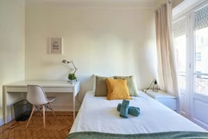 Desk bed pillows towels framed art bedroom at Bedroom in a 5-bedroom apartment in R. José Falcão, Lisbon - Room 1 in Lisbon Student Accommodation