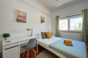 Bed desk chair artwork plant bedroom at Bedroom with private bathroom in a 6-bedroom apartment in R. do Arco do Carvalhão, Lisbon - Room 4 in Lisbon Student Accommodation