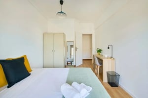 Bed desk wardrobe towels and pillows bedroom at Bedroom in a 5-bedroom apartment in Al. da Linha de Torres, Lisbon - Room 1 in Lisbon Student Accommodation
