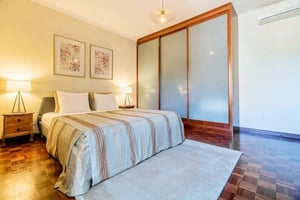 Bed bedside lamps framed art wardrobe bedroom at Rua Professor Fernando da Fonseca in Lisbon Student Accommodation