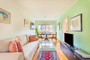 Sofa glass table TV artwork dining set living room at Rua de São Bento in Lisbon Student Accommodation
