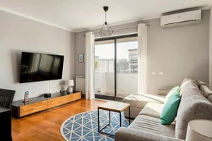 Sofa tv stand coffee table rug living room at Elegant Flat in Benfica - 10 min to City Center in Lisbon Student Accommodation